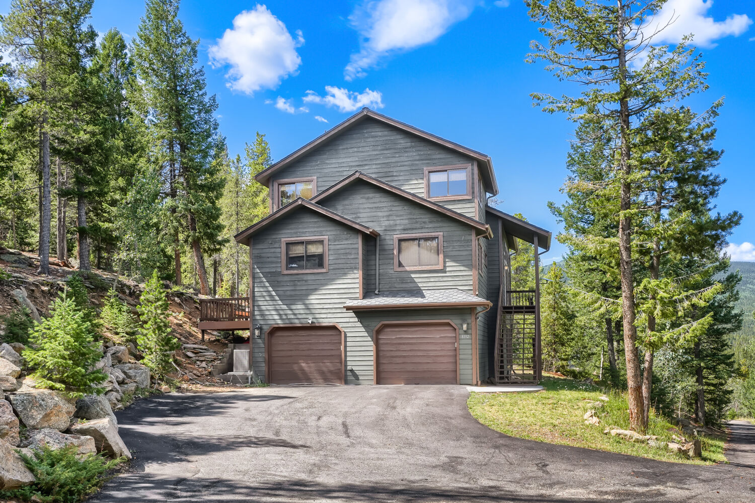Front view of the home with garage and stone retaining walls