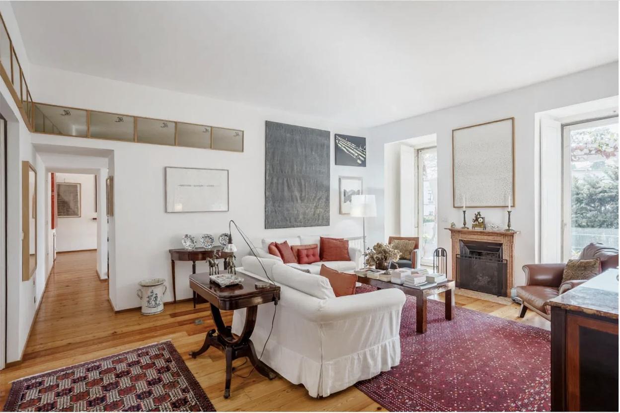 Second angle of the same bright living room with matching furniture, windows and fireplace